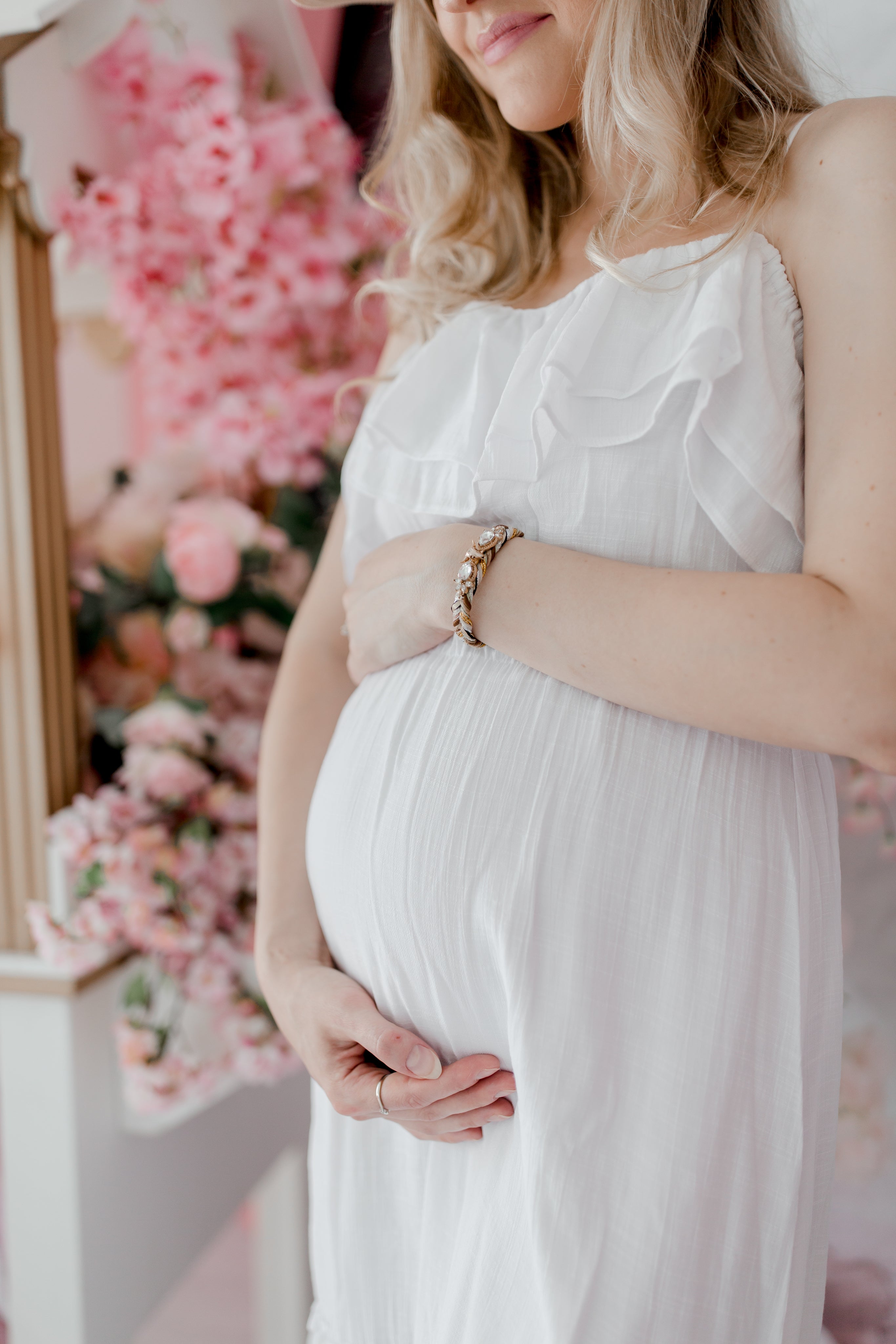 pregnant-woman-in-a-white-dress-holds-her-belly.jpg